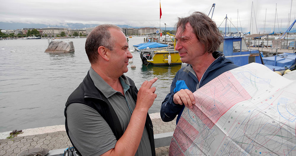 Zwei Männer am Genfersee und diskutieren über Landkarten